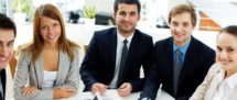 Image of business partners sitting at workplace and looking at camera